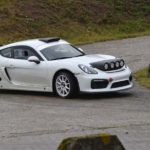 Porsche Cayman GT4 - pokonuje zakręt na trasie rajdu - widok z boku